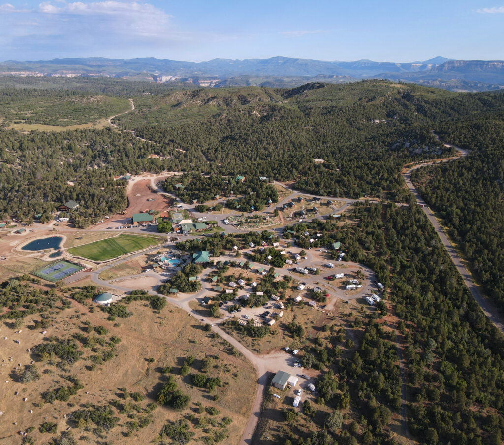 Aerial view of a rural community surrounded by mountains and greenery.